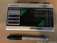 Front view of vintage Sony Walkman portable cassette player with graphic equalizer and FM/AM radio tuning scale, Sharpie marker for size reference