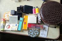Cosmetic case and assorted cosmetics arranged on a tabletop, showing variety and brands included.