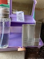 Purple Caboodles organizer with mirror containing Lancôme skincare and makeup products in box next to a bottle of micellar cleansing water