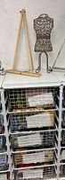 Photo of wooden easel and metal mini dress form positioned on top of the storage unit with fabric drawers visible below.