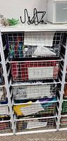 Photo of Elfa wire mesh storage unit showing all fabric drawers labeled by color/type.