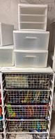Photo of Elfa storage unit with three metal wire basket shelves filled with fabrics and two metal wire add-a-shelves.