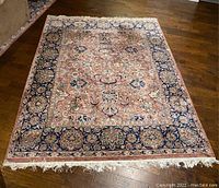 Top-down view of rectangular area rug on hardwood floor