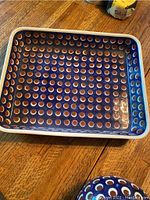 Rectangular square tray with a blue glaze background and circular brown and white dot pattern.