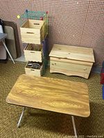 Photo showing wood chest, small table, three wood crates, and metal storage cubes with colorful frame.