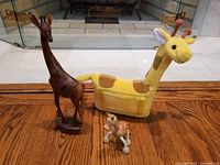 Photo showing all three giraffe items together: carved wood giraffe, plush giraffe picture frame, and Anamalz giraffe toy.