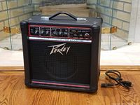 Front view of Peavey Transtube 258 EFX guitar amplifier showing controls and speaker grille, with power cord on floor.