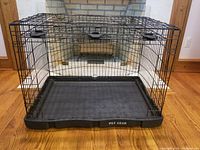 Front and side angled view showing the wire frame, plastic base with Pet Gear branding, and door clips.