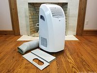 Front view of unit showing grille, control panel, exhaust hose and vent panels