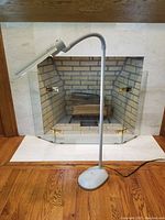 Full view of the Ott-Lite adjustable standing craft light positioned near a fireplace