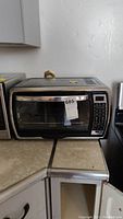 Front view of Oster convection oven showing glass door, control panel on right, and condition