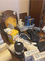 Photo of various medical supplies including shower chair seat, blood pressure cuff, gauze pads, boxes of insulin syringes, and Vicks vaporizer.
