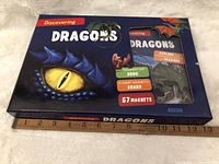 Front of boxed set showing dragon eye and contents window revealing book, board, and magnets.