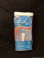 Front view of Life brand electric heating pad packaging, showing product image with controller and heating pad in blue color. Highlights features like automatic shut-off, extra sensing power technology, oversized pad (30 cm x 48 cm, 12" x 19"), and extra-long cord (2.7 m).
