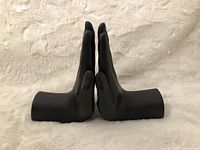 Side view of the black praying hands bookends showing flat bases and finger details.