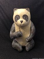 Front view of the sitting panda figurine holding bamboo stick with visible textured paint.
