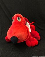 Front view of vintage Poinsetter the Christmas Pooch plush dog in bright red showing large nose, eyes, ears, and sitting posture