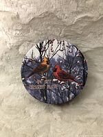 Top view of a closed tin box showing cardinal dessert plate design on lid with two birds on bare branches and text '4 PC SET DESSERT PLATE'