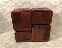 Front view of four stacked wooden containers with black labeled text on front (Peanuts, Tea, Coffee, Sugar) showing rich wood grain.