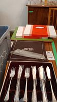 Photo of Dexam cutlery set displayed in original boxes, showing forks, knives, and spoons wrapped in plastic.
