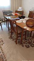 Full view of walnut dining table with chairs and staging items