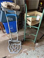 Photo front view of two moving dollies showing relative size and condition with rust and chipped paint.