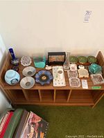 Overview of wooden shelf with various glass, ceramic, metal and decorative items