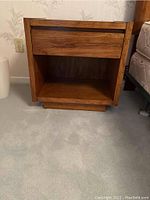 Front view of a Lane night table showing one drawer and an open shelf underneath in wood finish.