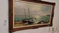 Framed oil painting of seascape with two boats, showing full view in ornate frame.