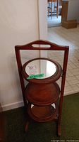 Front view of the wooden 3-tier stand showing the round mirror on the top tier and wooden middle tier.