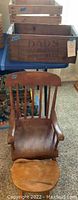 Photo showing wooden armchair with carved seat and spindle back next to a large wooden crate marked 'Dad's Old Fashioned Root Beer'