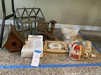 Overview of bird houses, flower press kit, and shell collections laid on carpet