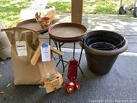 Outdoor garden items including bird feeders, planters, side tables, and bird seed.