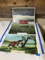 Three scenic panels laid flat on mattress with Budweiser sign frame behind