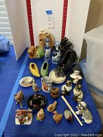 Full overview of vintage ceramic novelty items showing variety of animal and human figurines, shoe ceramics, and decorative pieces.