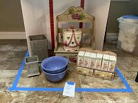 Full lot photo showing all items together in the lot: wooden spice rack shelf, ceramic jar, ceramic spice containers, metal utensil holders, and blue stoneware bowls.