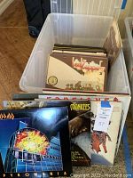 Bin of LP records showing album covers from Def Leppard, The Monkees, and others
