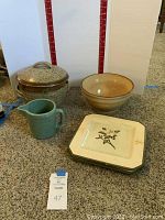 Full lot showing all stoneware and ceramic items including lidded pot, bowl, pitcher, and plates.