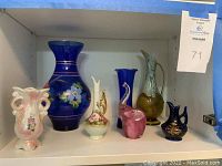 Full collection of six vintage decorative items including vases and pitchers on a white shelf