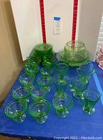 Table display of footed dessert glasses in front, stacked plates and handled cups behind