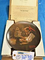 Photo of the Norman Rockwell 'The Ship Builder' plate in original foam packaging with Certificate of Authenticity and information sheet in a cardboard box.
