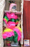 Vintage 24-inch Chiquita Dynasty Doll in original box wrapped in bubble wrap, showing colorful hot pink, green, and yellow dress.