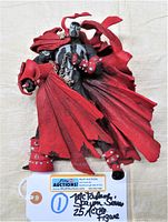 Front view of McFarlane Spawn action figure showing red tattered cape, black and white suit, chains and gauntlets.