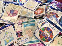 Photo showing a variety of sealed mylar balloon packages with messages like Thank You, Wedding, Happy Birthday, and Baby Shower.
