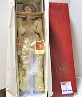 Full view of the vintage doll in original box with stand and Certificate of Authenticity visible
