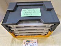 Stacked plastic storage drawers containing clear small bead compartments with note identifying lot as crystal beads