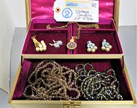 Photo showing overall vintage jewelry lot inside open velvet-lined vintage jewelry box.
