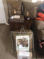 Comforter set and matching pillows on wooden table with packaging showing brand Damasté and oversized king size.