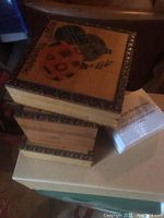 Stacked decorative wooden boxes with intricate edge design and painted lid art.