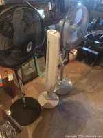 Two fans pictured side by side in basement setting, showing overall appearance and size comparison.